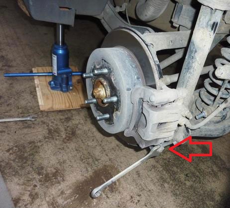 Открутить болт нижнего поперечного рычага задней подвески на автомобиле Hyundai ix35